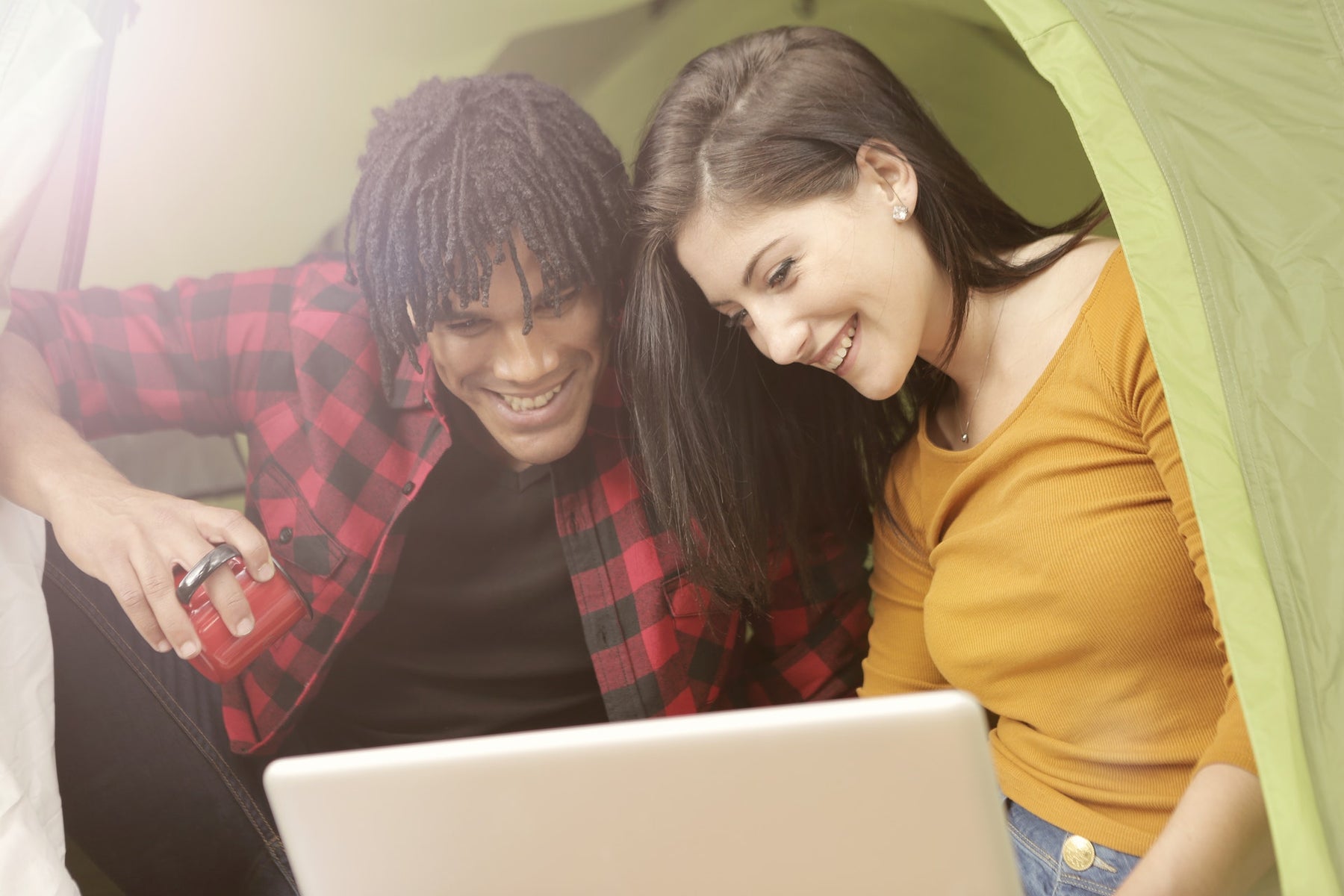 A couple using a laptop while camping via a dual fuel inverter generator