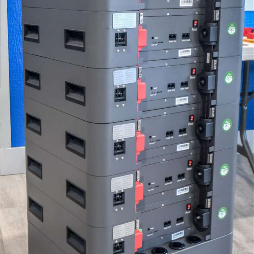 A tall stack of connected battery modules displays the ports and handles of the Rubix Stack Series 48 Volt 100AH Lithium Battery-RS-48100