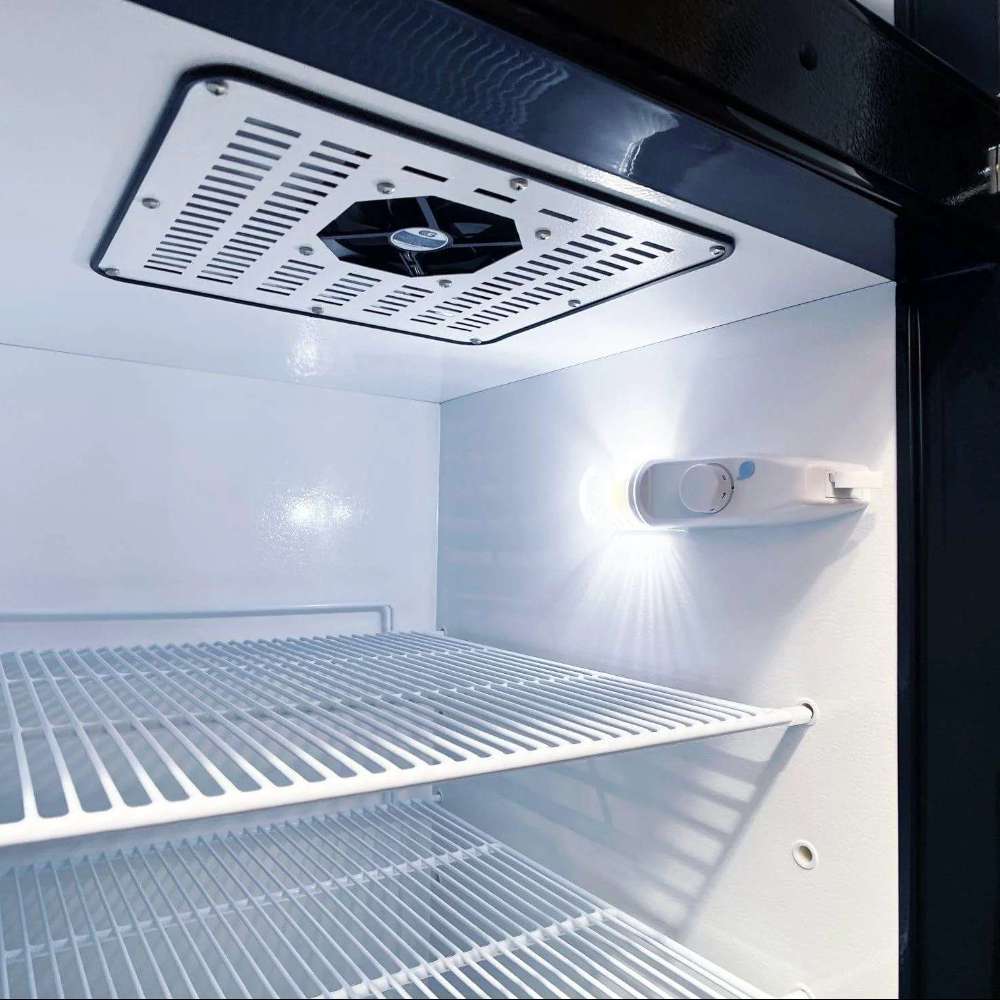 Close interior view shows SunStar ST-16RF-SS 16 cu.ft. DC/AC Refrigerator - Stainless Steel with a ceiling fan vent, wire shelf, and bright white interior