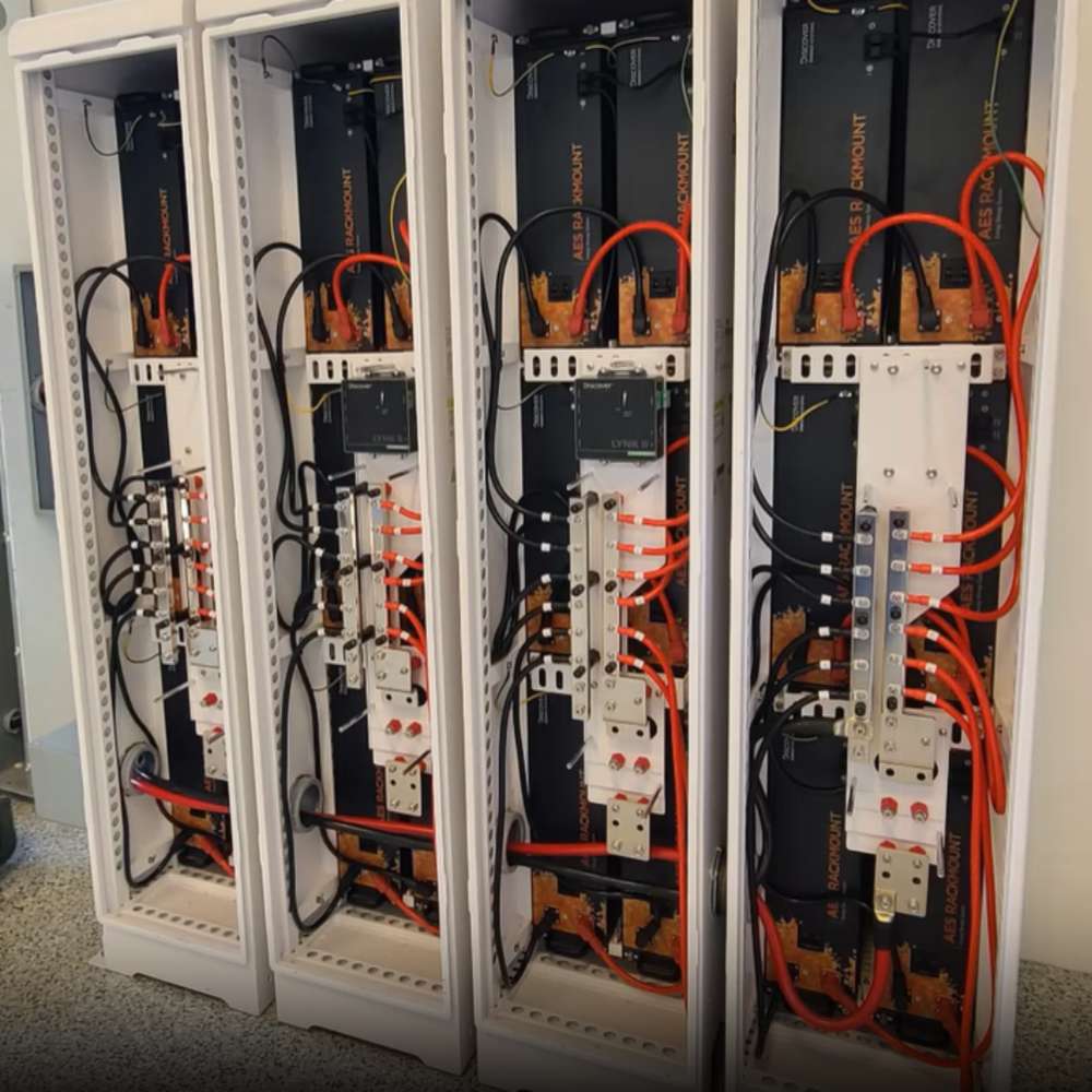 Four open cabinets display multiple wired battery modules of the Discover Energy AES Rackmount ESS 30kWh Slimline Enclosure-950-0053 installed in parallel