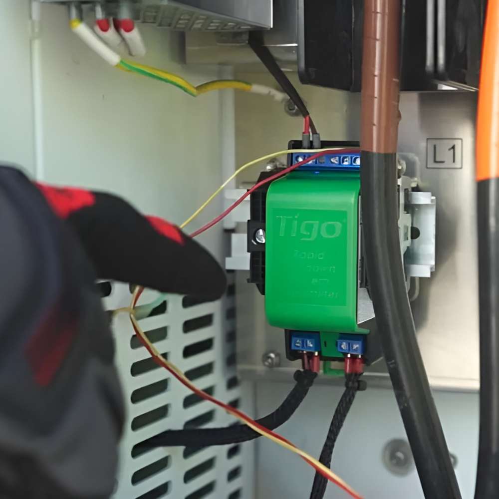 Gloved hand works inside an electrical box on a green Tigo component connected to the Tigo Energy 7.6kW Hybrid Inverter/Charger-601-2107K6-0002