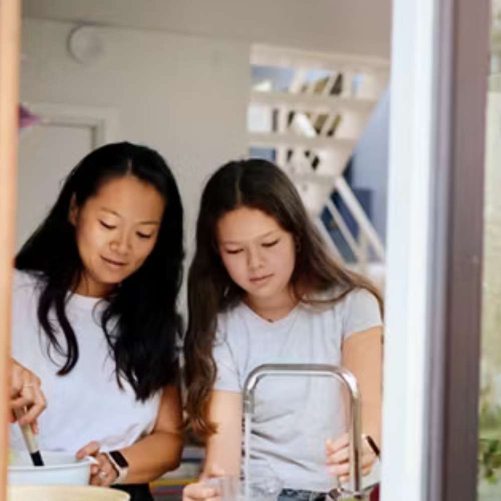 Grundfos PC12-211F 500' Roll Pump Wire supports everyday home utilities, represented by two people preparing food together at a kitchen counter