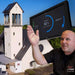 Man gestures in front of a solar-equipped church powered by the Victron Energy 12.8V 100Ah (M8) SuperPack Lithium Battery High Current w/ Internal BMS-BAT512110710