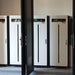 Multiple tall white battery cabinets standing in a room behind an open door represent the Pytes Forest RB 6 Slot Battery Cabinet for E-Box-48100R - 110409100166