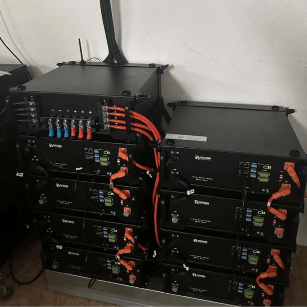 Renon Power EBrick Rack Series 5.12 kWh LiFePO4 Stackable Battery Module-EBRICKR5K is shown as multiple black battery units connected with thick orange cables