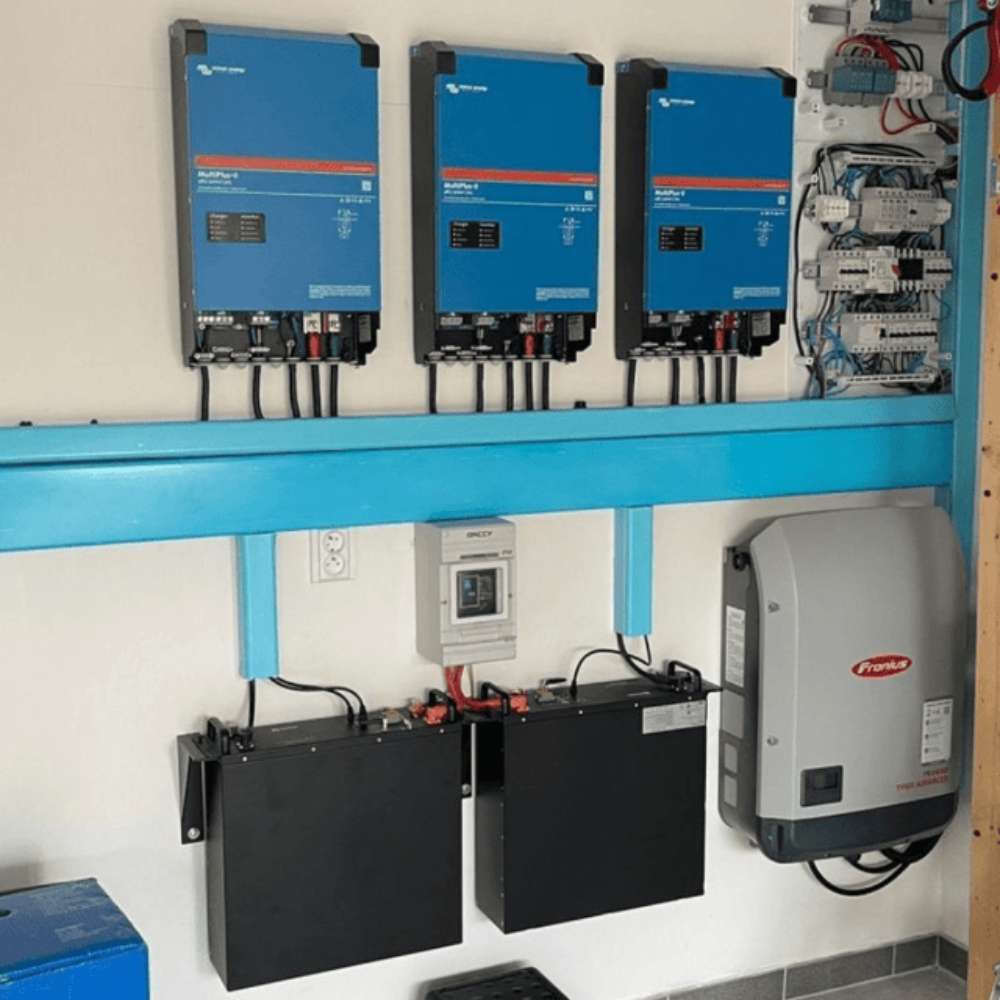 Renon Power EBrick Rack Series 5.12 kWh LiFePO4 Stackable Battery Module-EBRICKR5K is shown in a wall-mounted energy system with blue inverters and organized wiring