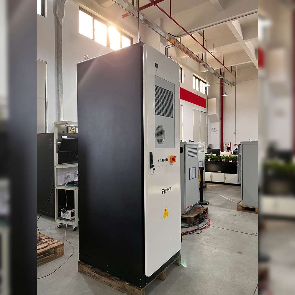 Renon Power ECube 60AP 61kWh Lithium Battery System-ECUBE61K is displayed from a side angle in an industrial workspace, highlighting its large metal enclosure and cooling vents