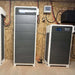 Renon Power Xtreme HV Series 10.24kWh Stackable Battery Module-XTREMEHVBCU is a tall indoor battery cabinet with a front display installed against a wooden utility room wall with visible wiring