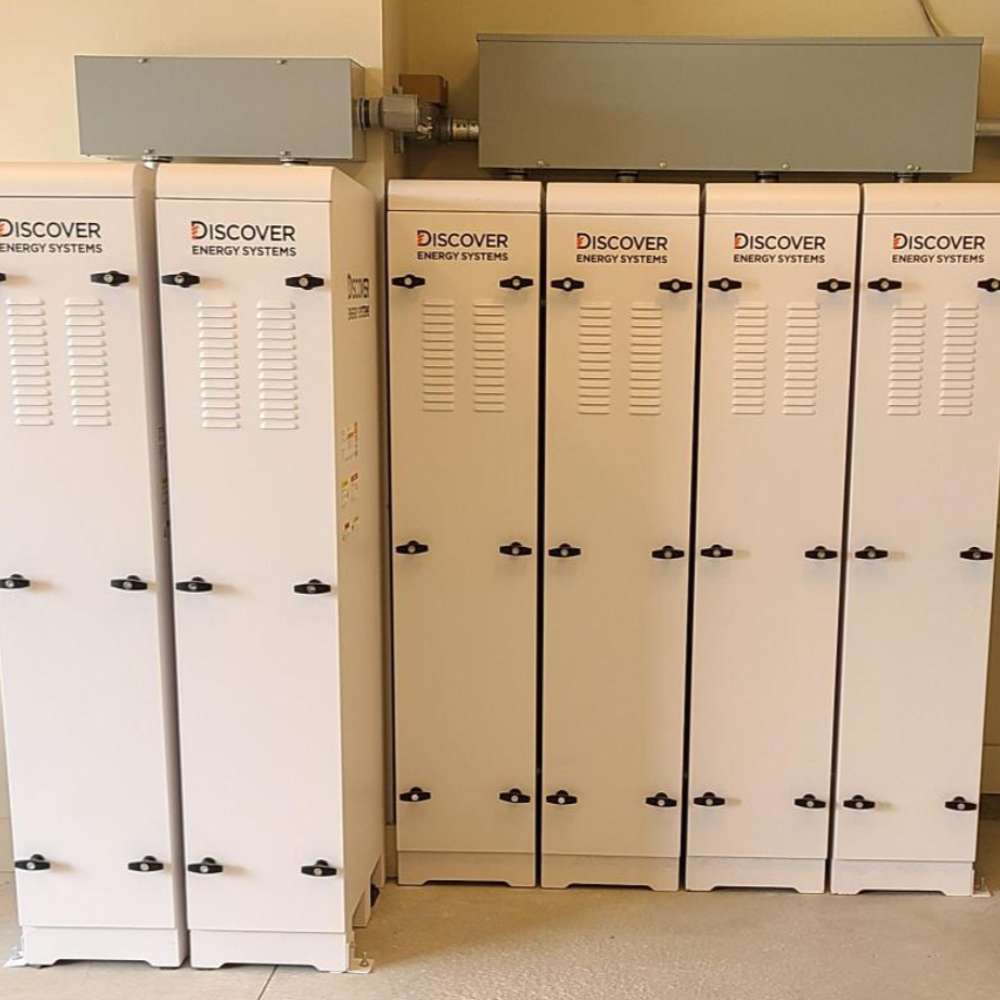 Several closed white cabinets labeled Discover Energy AES Rackmount ESS 30kWh Slimline Enclosure-950-0053 stand in a row against a wall