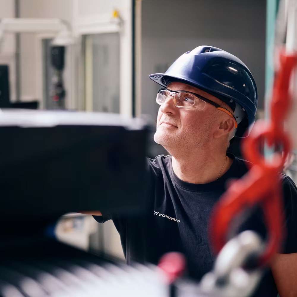 Technician working with industrial machinery highlights professional systems powered by the Grundfos PC12-211F 500' Roll Pump Wire