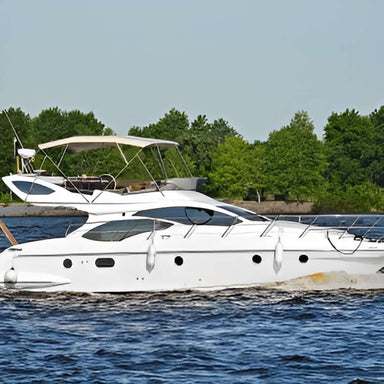 White yacht glides across the water with trees in the background, powered behind the scenes by systems like the Magnum Energy ME Series ME2012-U 2000W 12VDC Modified Sine Inverter Charger