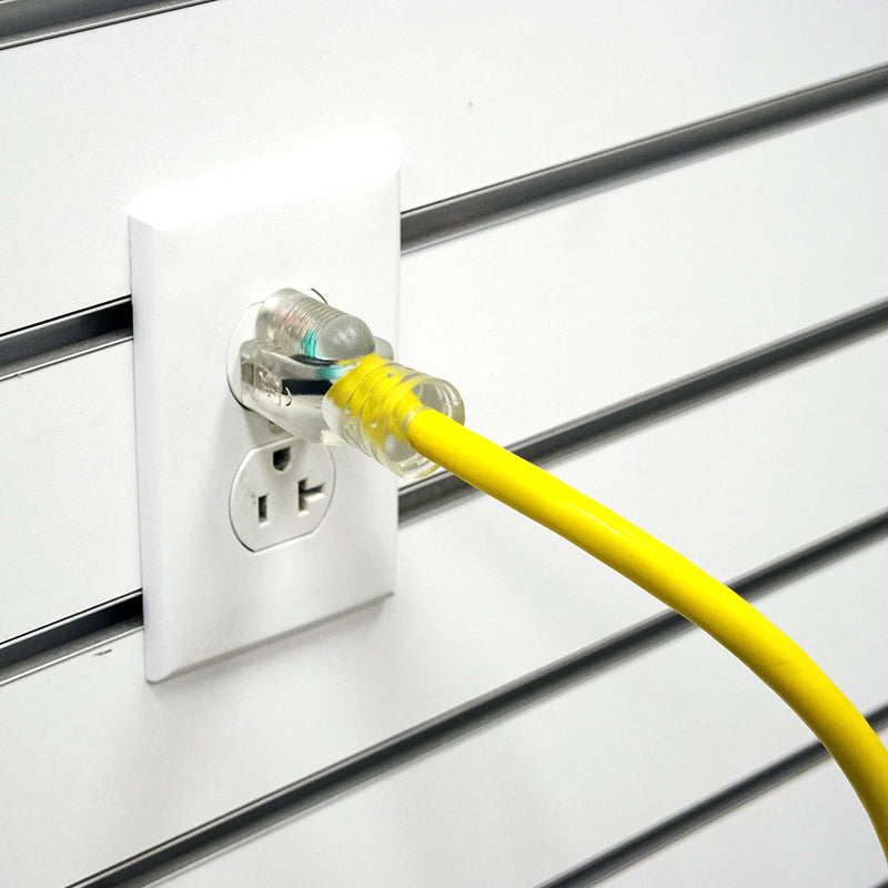 Yellow DuroMax single tap extension cord plugged into a standard wall outlet, showing its compatibility and lighted plug feature.