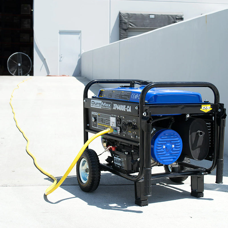 DuroMax portable generator outside connected to a heavy-duty yellow extension cord, exemplifying outdoor power equipment.