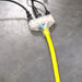 DuroMax extension cord triple tap plugged into multiple power cords on a concrete floor, showing the clear plug with light indicator.