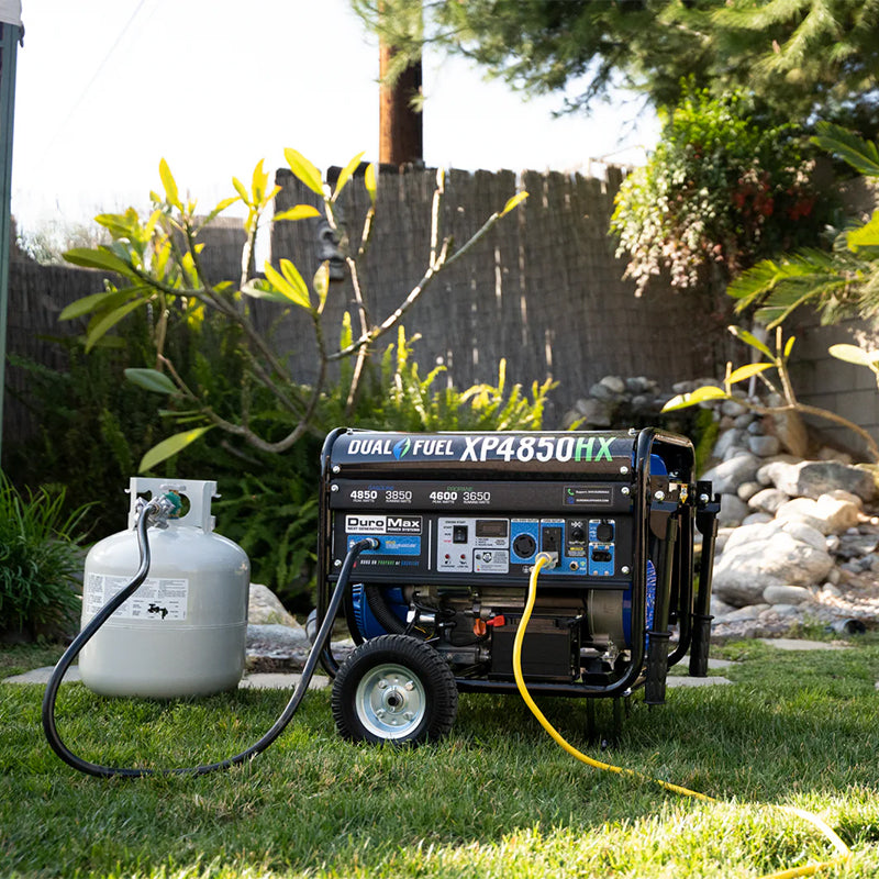 Quality DuroMax XP4850HX generator with dual fuel function, stationed on a grassy lawn for easy outdoor maintenance.