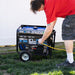 Individual using a DuroMax XP4850HX portable generator outdoors, demonstrating the generator's user-friendly design and functionality.