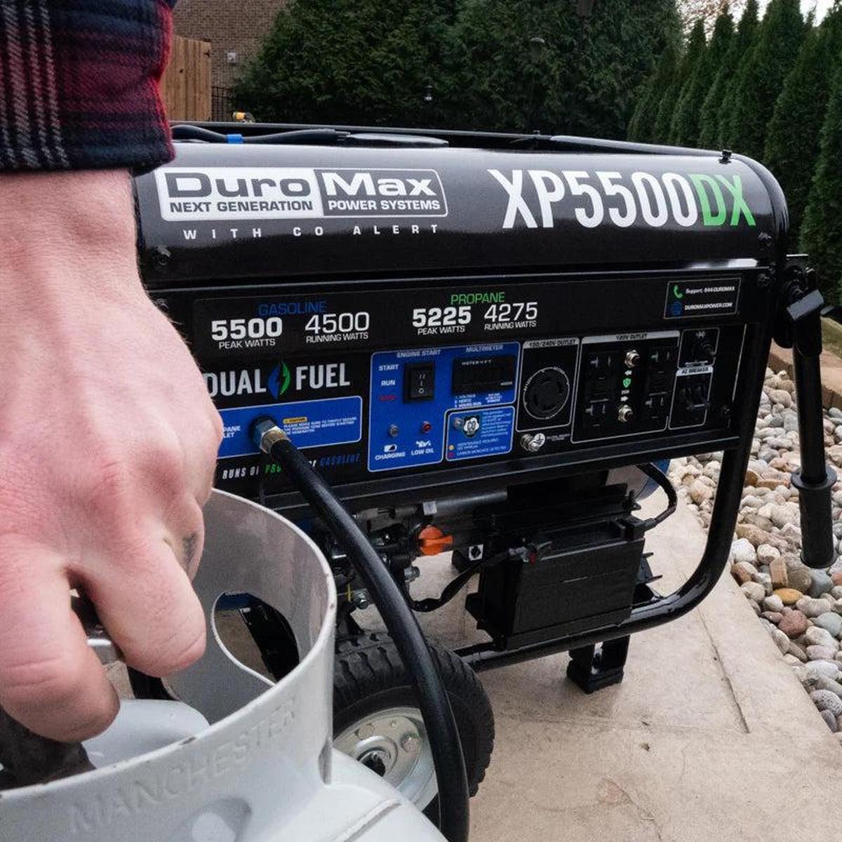 Close-up of a man fueling a Duromax XP5500DX quality generator with a propane tank.