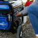 Close-up of a hand starting a Duromax XP5500HX portable generator, demonstrating its simple and efficient operation.