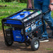 Man maneuvering a Duromax XP5500HX quality generator through a garden, showcasing ease of transport.