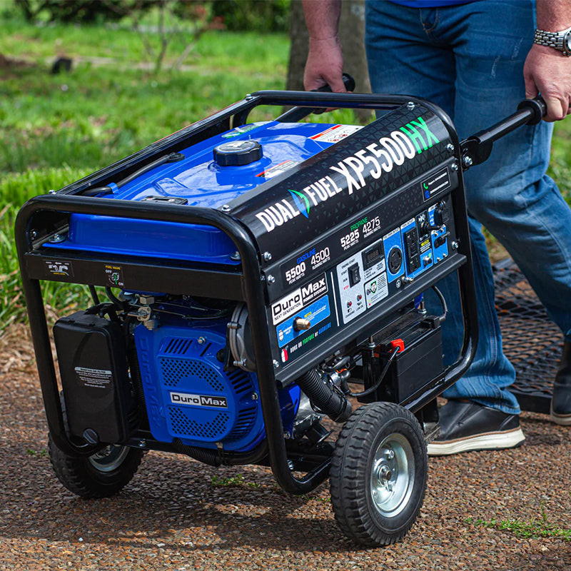 Man maneuvering a Duromax XP5500HX quality generator through a garden, showcasing ease of transport.