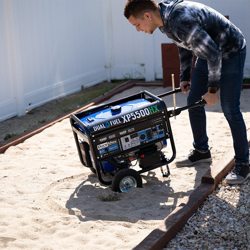 Man preparing a Duromax XP5500HX portable generator for use, highlighting its practicality in outdoor settings.