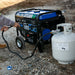 Duromax XP5500HX generator set up with a propane tank outdoors, illustrating its convenience for external power needs.