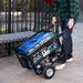 A person pushing a Duromax XP5500HX portable generator through a park, showcasing its user-friendly portability.