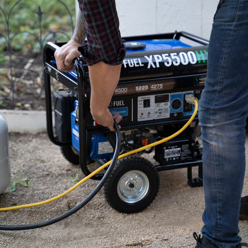 Person operating a Duromax XP5500HX portable generator, emphasizing the convenience of its dual-fuel technology.