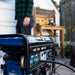 Man standing near a Duromax XP5500HX portable generator, highlighting its compact design and ease of use in a residential setting