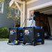 Man setting up a DuroMax parallel kit between two generators, demonstrating ease of use for extended power supply.