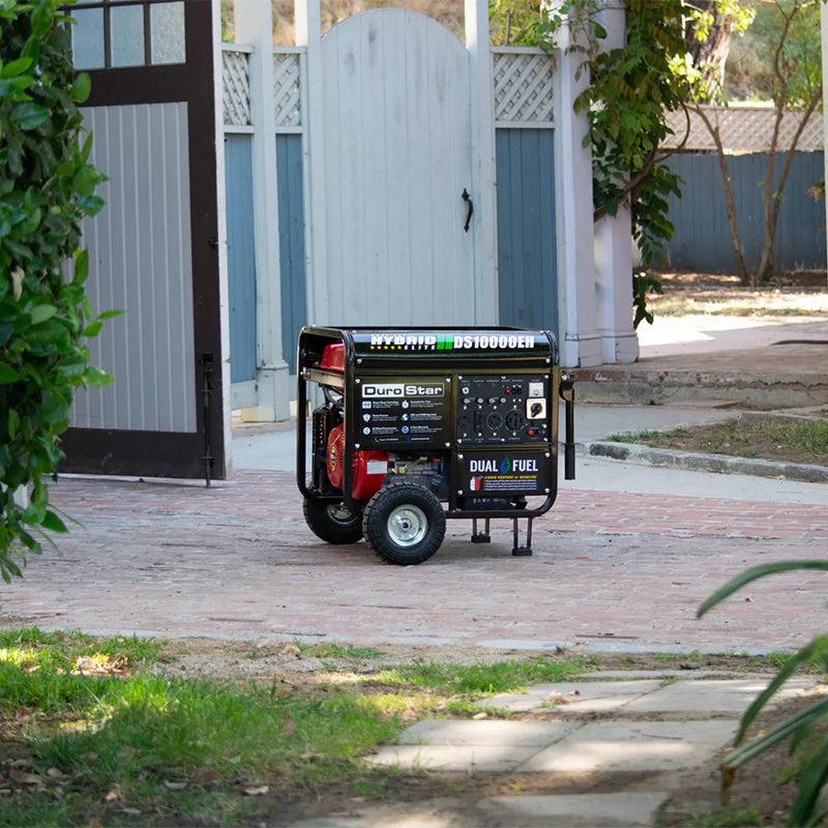 A distant view of the DuroStar DS10000EH quality generator positioned on a suburban driveway, showcasing its portability and compact size.