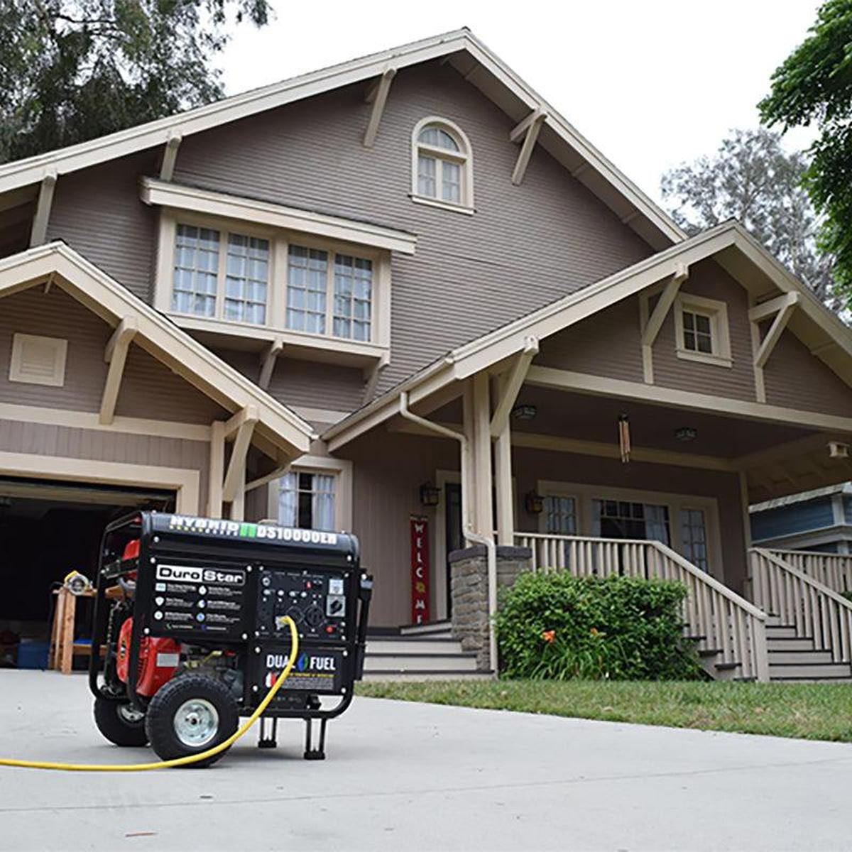 DuroStar DS10000EH generator positioned in front of a residential home, illustrating its practical application for home backup power.