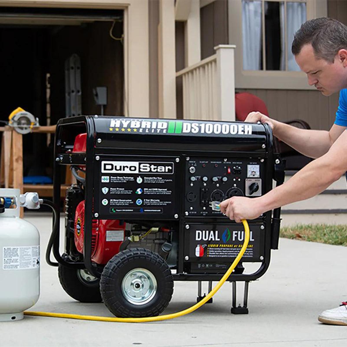 User connecting a yellow power cord to the DuroStar DS10000EH dual fuel quality generator, demonstrating ease of use and versatility.