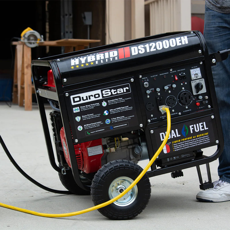 DuroStar DS12000EH Dual Fuel Portable Generator connected to a propane tank, ready for use in a home workshop.