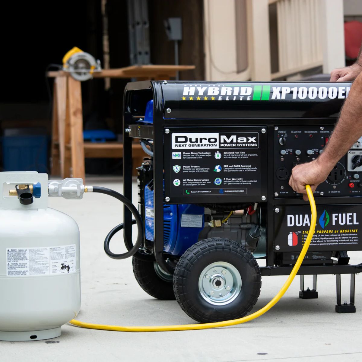 Hooking up the power cable to propane tank set up of DuroStar XP10000EH outside the garage