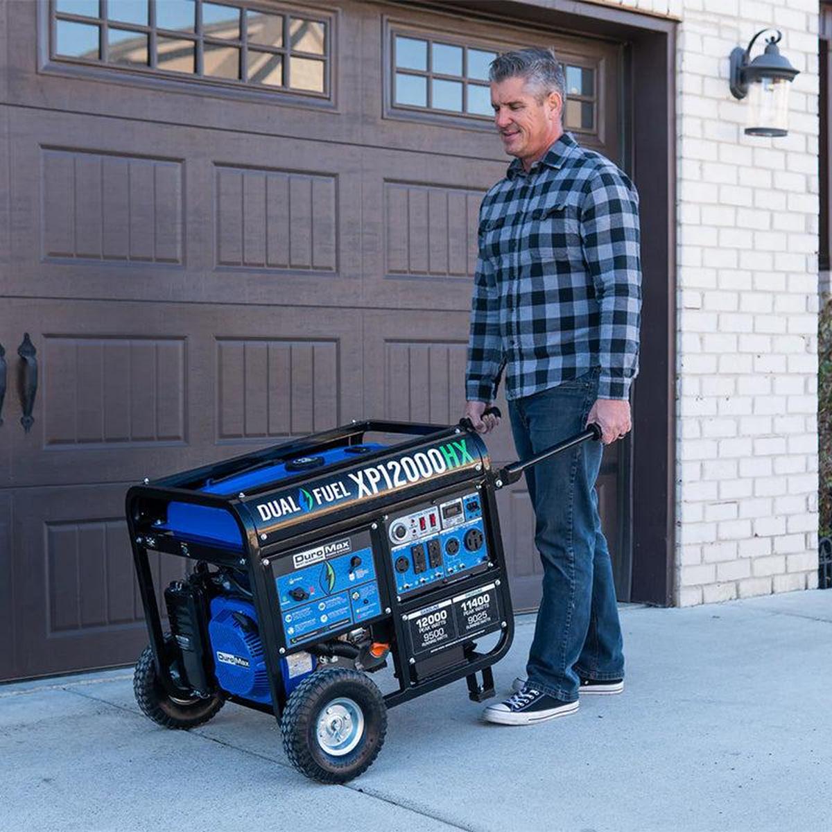Man easily maneuvering a Duromax XP12000HX portable generator with dual fuel capability outside a residential garage, demonstrating the generator's mobility.