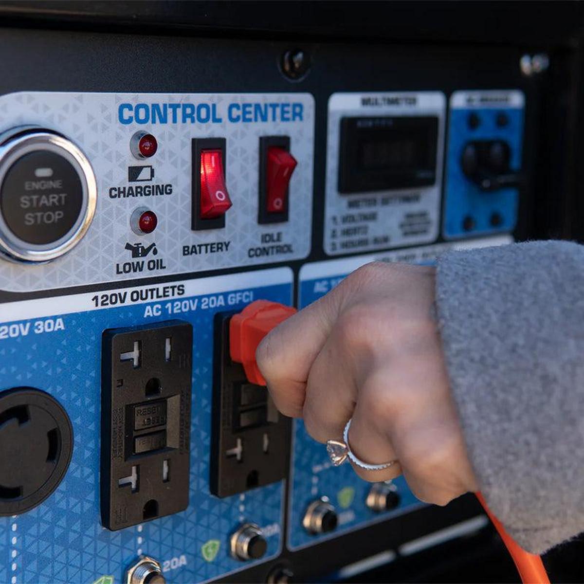 User engaging the control center on a Duromax XP12000HX generator, illustrating the user-friendly operation and accessible power outlets.