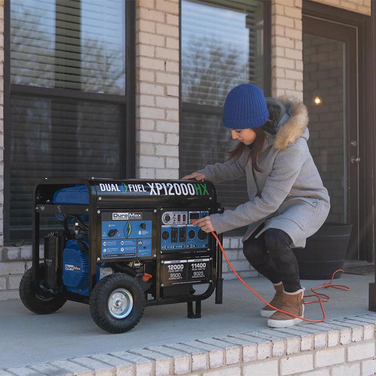 Woman preparing to connect a Duromax XP12000HX generator, demonstrating the practicality of portable generators for residential power needs.