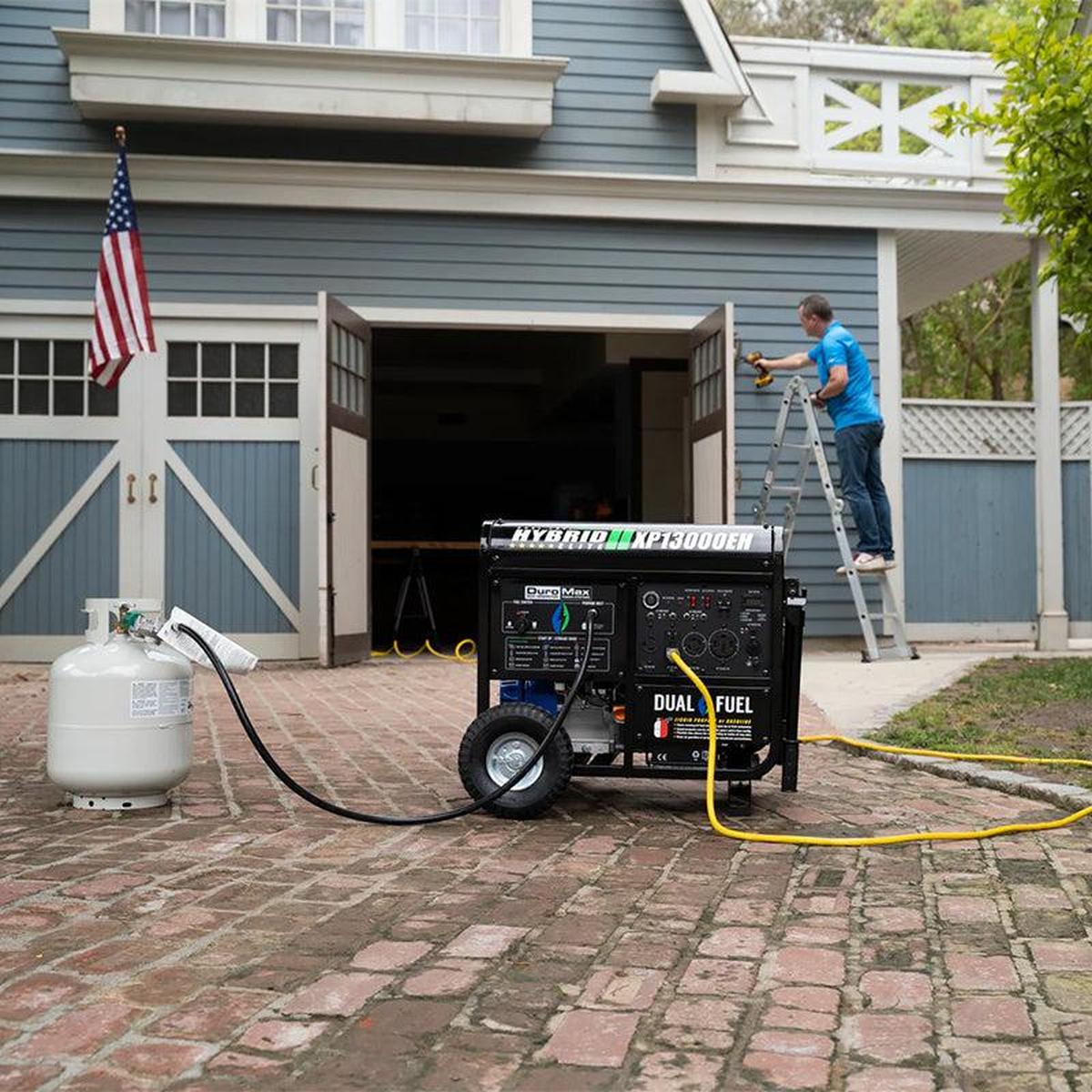 DuroMax hybrid generator providing power in a residential backyard, with extension cord for outdoor activities.