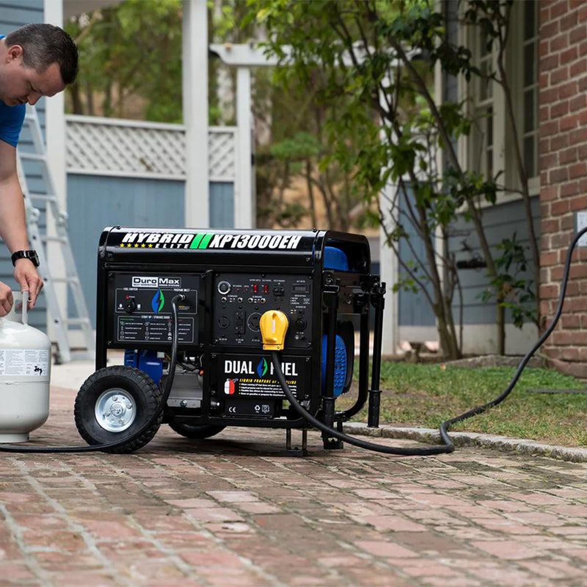 Man connecting a propane tank to a DuroMax XP13000EH portable generator, demonstrating ease of use.