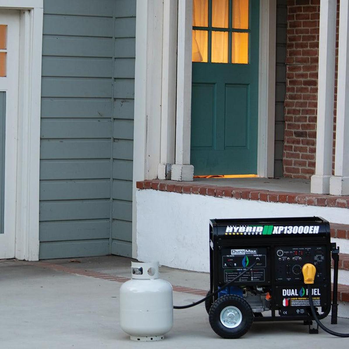DuroMax XP13000EH portable generator placed near a home entrance, showcasing readiness for emergency power with a propane tank.