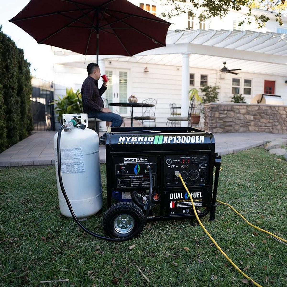 Man enjoying a cup of coffee in his backyard with a DuroMax portable generator ensuring power backup.