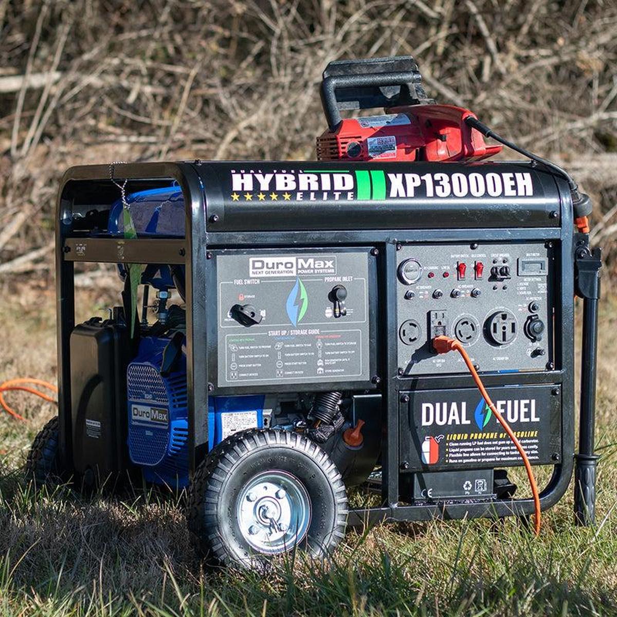 DuroMax quality generator in a field, connected with an extension cord to power tools, demonstrating its outdoor capabilities.
