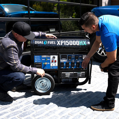 Two men examining the wheel of the DuroMax XP15000HX quality generator, demonstrating its portability.